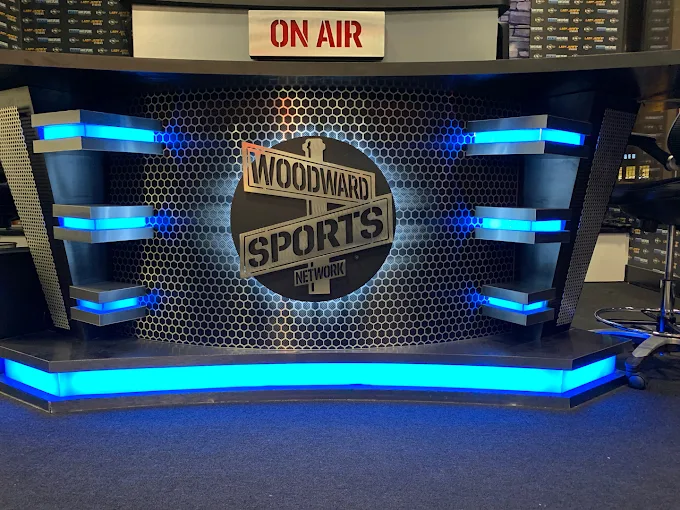 Woodward Sports Network anchor desk with on-air sign